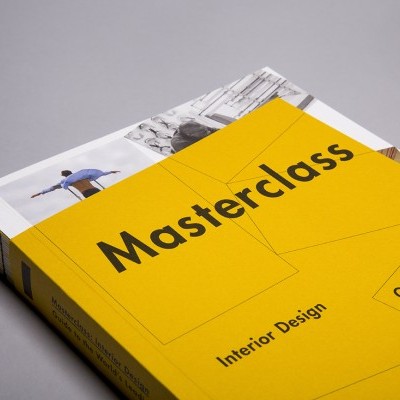 Livro 'Masterclass Interior Design' com capa amarela sobre superfície cinzenta