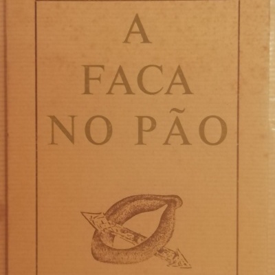 Capa de livro castanho com título 'A FACA NO PÃO' e autor 'EDGAR CARNEIRO' com ilustração de faca e pão