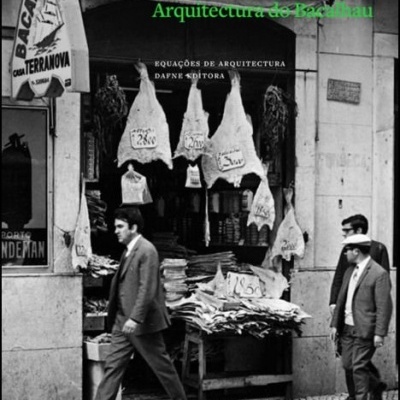 Loja com bacalhaus pendurados e empilhados com letreiro BACALHAU CORSA TERRANOVA e três homens a caminhar em calçada portuguesa