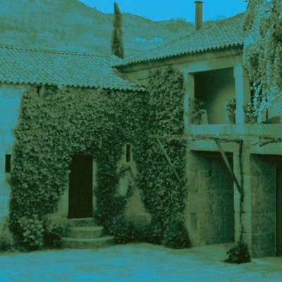 Capa de livro 'A CIDADE E AS SERRAS' de Eça de Queirós com imagem de edifício antigo coberto de videiras.