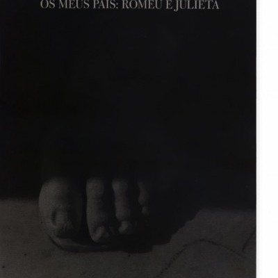 Capa de livro preta com texto branco e imagem escura de pés numa estátua