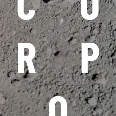 Superfície de terra seca e arenosa com letras brancas C O R P O