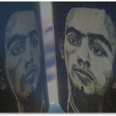 Copo preto com rosto de homem ilustrado em cinza, refletido numa superfície brilhante