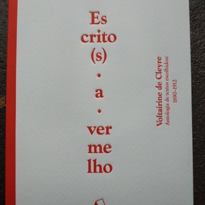 Livro branco com texto vermelho e logotipo da editora sobre superfície escura