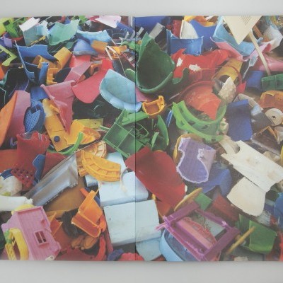 Páginas abertas com imagem de peças plásticas coloridas fragmentadas