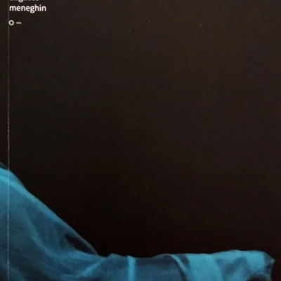 Capa de livro preta com tecido azul e texto no canto superior esquerdo