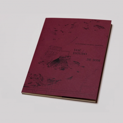 Livro vinho com texto e ilustrações pretas sobre superfície cinzenta