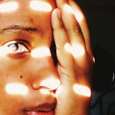 Capa de livro com rosto humano parcialmente coberto, faixas de luz e sombra, texto ERROSÃO gisela casimiro