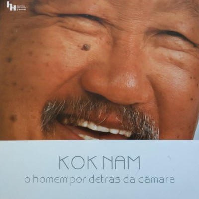 Capa de livro com rosto de homem asiático sorridente e texto 'KOK NAM o homem por detrás da câmara'