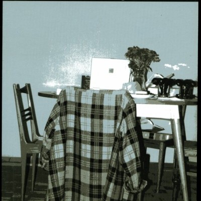 Livro com capa ilustrando uma mesa com cadeiras e camisa xadrez pendurada