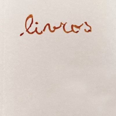 Capa de livro branca com escrita manuscrita 'livros' em castanho