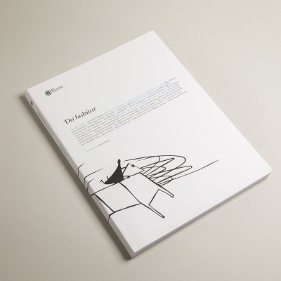 Livro branco com texto e ilustração abstrata preta numa superfície clara