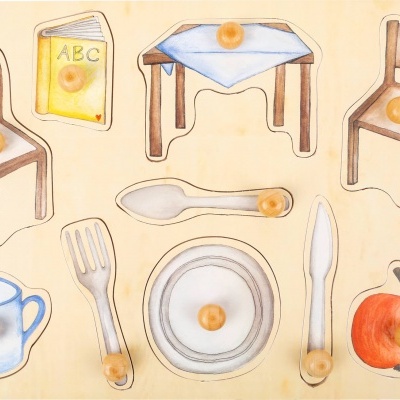 Quebra-cabeça de madeira com peças de objetos domésticos e de escola, cada uma com pomos amarelos.