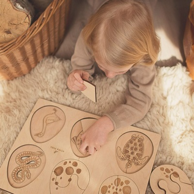 Quebra-cabeça de madeira com animais marinhos e criança a brincar