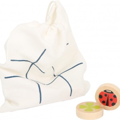 Saco de tecido branco com padrão azul e peças de madeira com desenhos de joaninha e flor