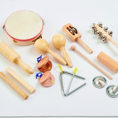 Conjunto de instrumentos musicais infantis em madeira e metal sobre fundo branco