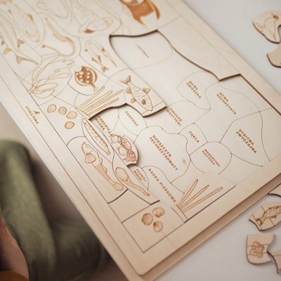 Jogo educativo de madeira com peças de alimentos e etiquetas organizadas num tabuleiro.