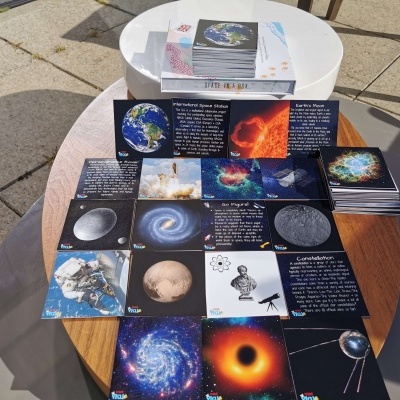 Cartões com imagens e textos relacionados com o espaço sobre mesa de madeira ao ar livre.