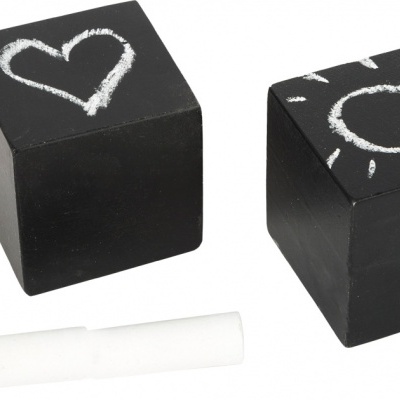 Dois cubos pretos tipo quadro de ardósia com desenhos a giz, coração e sol, com giz branco ao lado