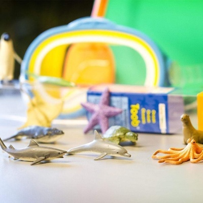 Brinquedos marinhos em plástico espalhados sobre superfície branca