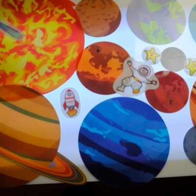 Adesivos coloridos de planetas, astronauta, foguetão e estrelas sobre fundo branco