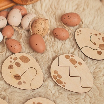 ovos decorativos castanhos e peças de madeira clara com padrões castanhos em tecido felpudo