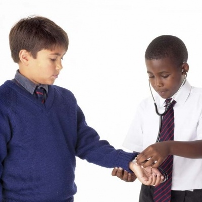 Duas crianças em uniformes escolares com estetoscópio fundo branco