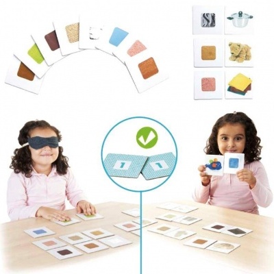 Crianças jogando jogo de cartas de texturas e imagens numa mesa clara