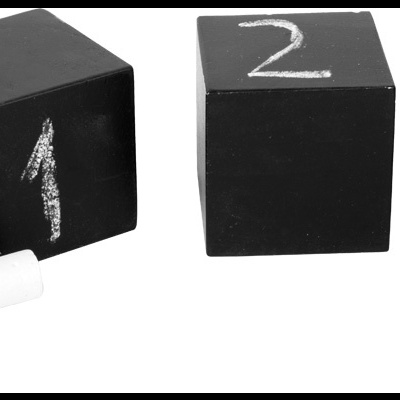 cubos pretos com números a giz e pedaço de giz branco