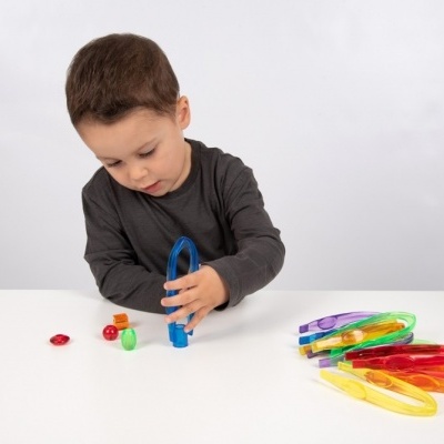 Criança com brinquedo de construção colorido em mesa branca