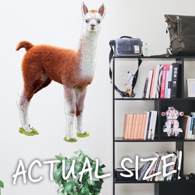 Quebra-cabeças de lhama tamanho real junto a estante com livros e brinquedos.