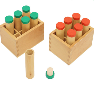 Conjuntos de tubos cilíndricos em madeira com tampas coloridas dentro de caixas de madeira