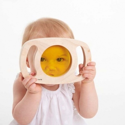 Bebé com brinquedo de madeira com círculo amarelo