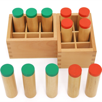 Tubos de madeira com tampas verdes e vermelhas em caixas de madeira