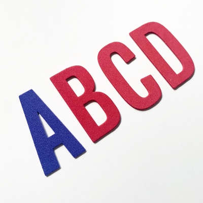 Letras em espuma azul e vermelha sobre fundo branco