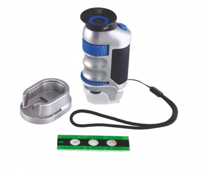 Microscópio portátil prateado e azul com base metálica e régua verde com moedas