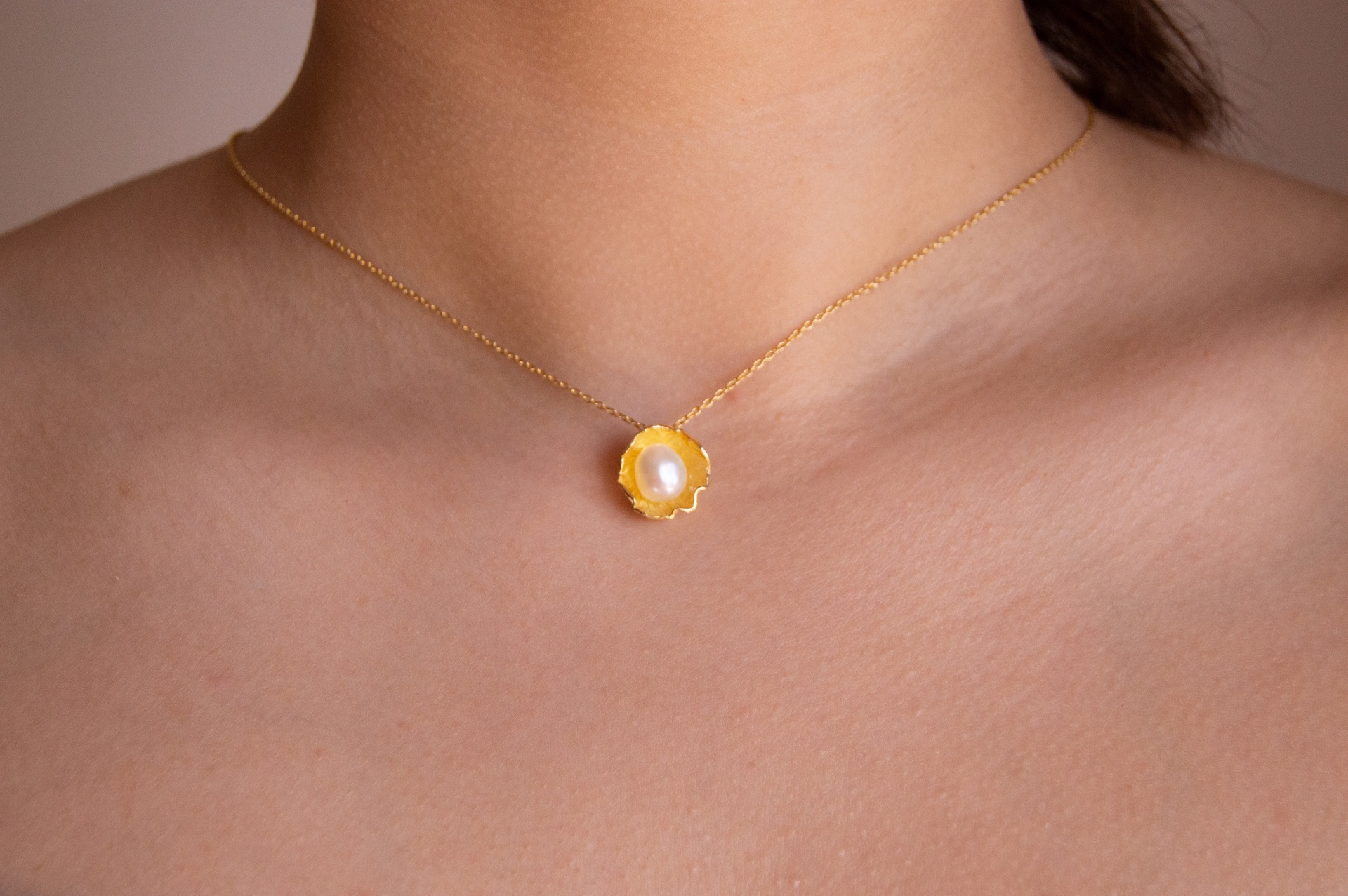 Colar Ostra Pequena Colar dourado com pendente de flor e pérola ao pescoço