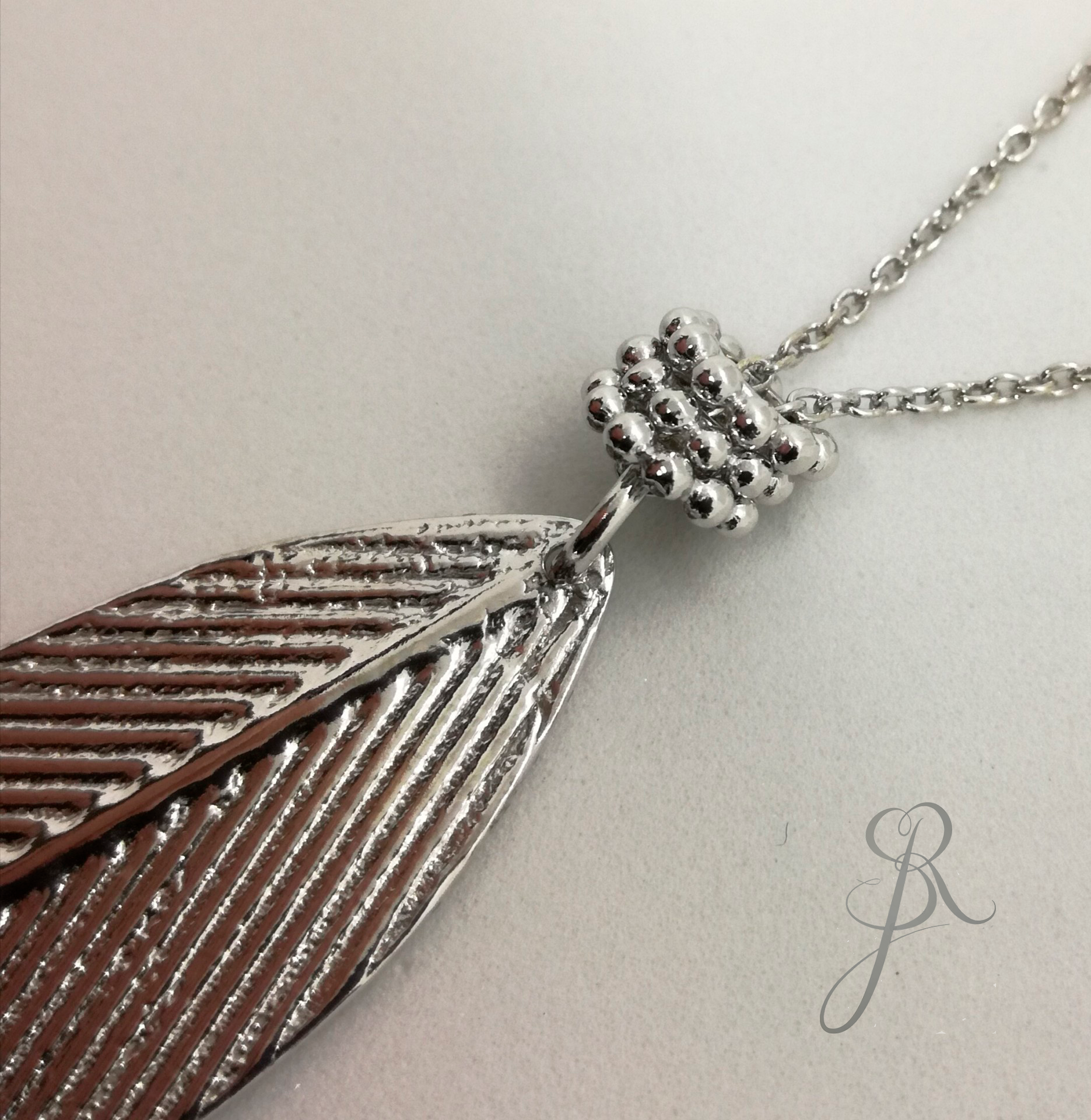 Colar Sylvia Colar com pendente em forma de pena prateado texturizado com corrente de elos e detalhe esférico