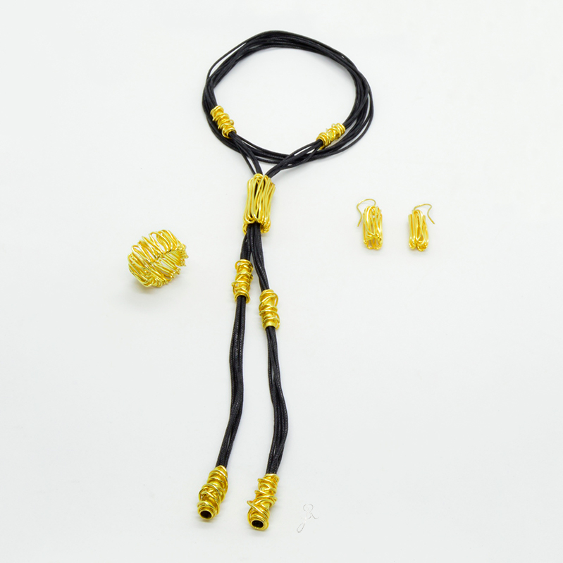 Anel de Fios Conjunto de joalharia com colar, anel e brincos pretos e dourados sobre fundo branco