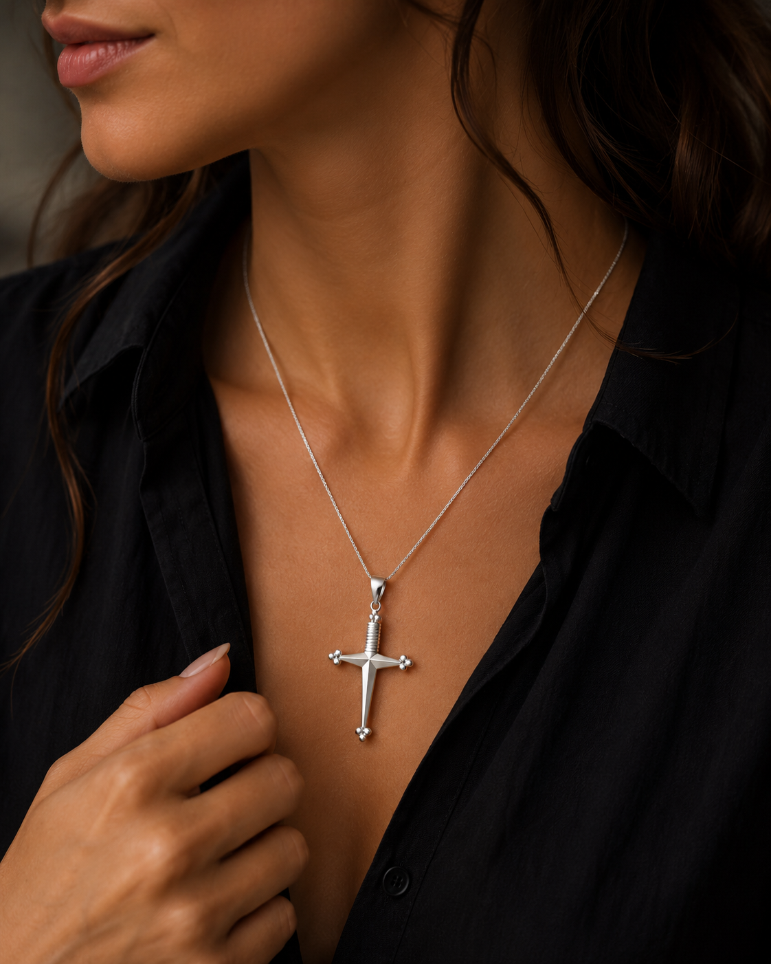 Cruz Espada Colar com pendente de cruz prateada em mulher com camisa preta
