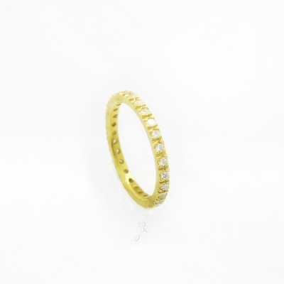 aliança de ouro amarelo com diamantes sobre fundo branco