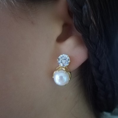 Brinco com pedra brilhante e pérola em orelha