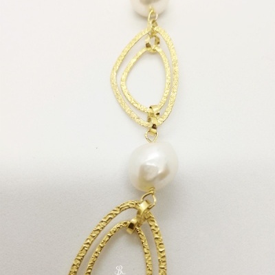 Colar dourado com pérolas brancas sobre fundo branco