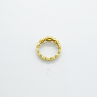 Anel dourado com textura facetada sobre fundo branco