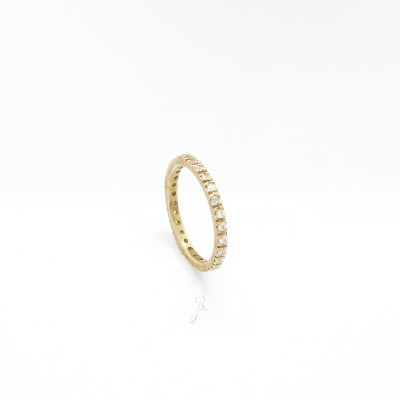 Anel de ouro amarelo com pedras transparentes ao longo da circunferência em fundo branco