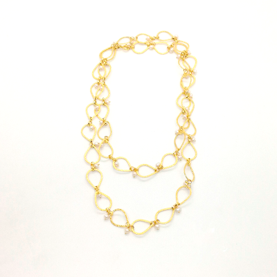 Colar dourado com elos em forma de infinito e pérolas, sobre fundo branco