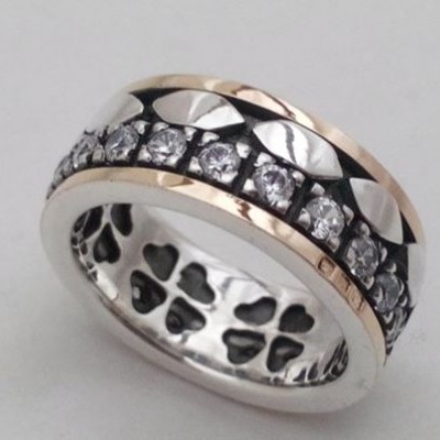 Anel metálico com pedras e desenho de corações no interior