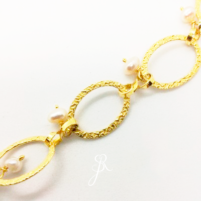Bracelete dourado com elos ovais texturizados e pérolas brancas