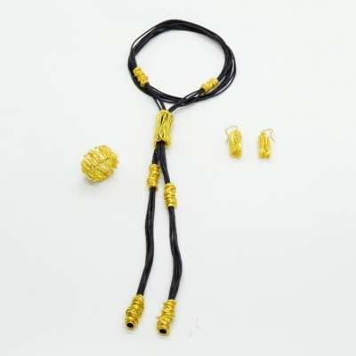 Conjunto de joalharia com colar, anel e brincos pretos e dourados sobre fundo branco