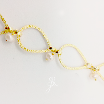 Colar dourado com elos em forma de gotas e pérolas brancas